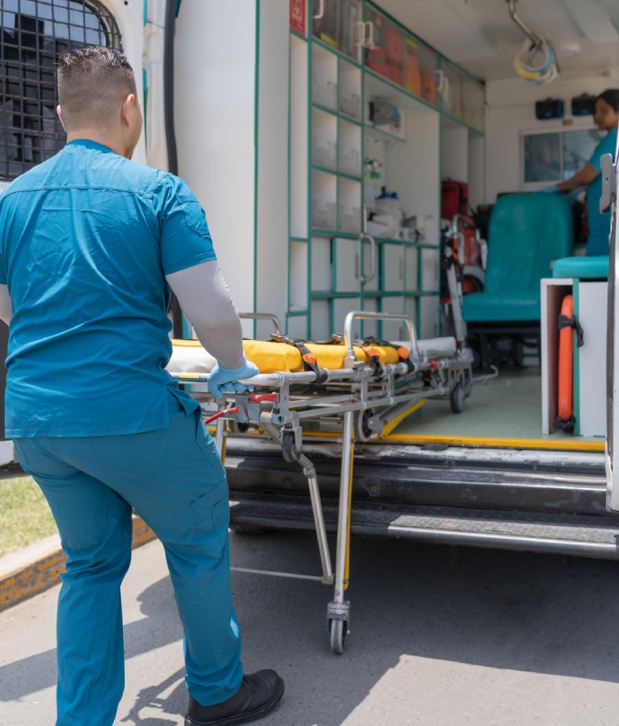 Ambulancier préparant un brancard pour un transport médical en véhicule sanitaire
